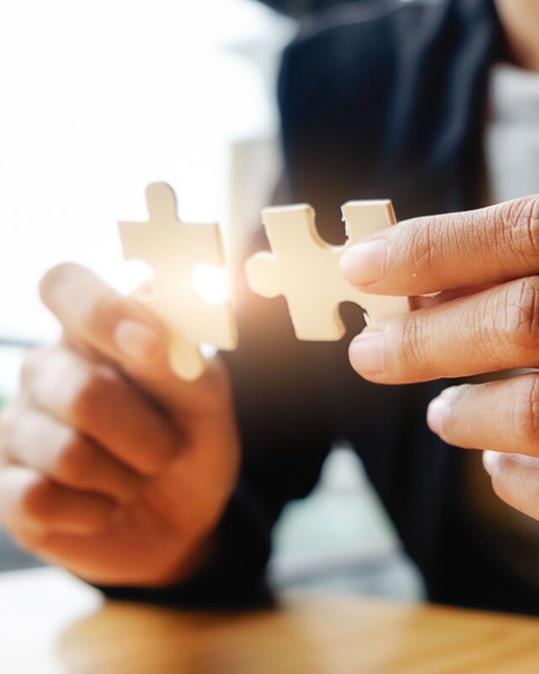 Zwei Puzzleteile in der Hand